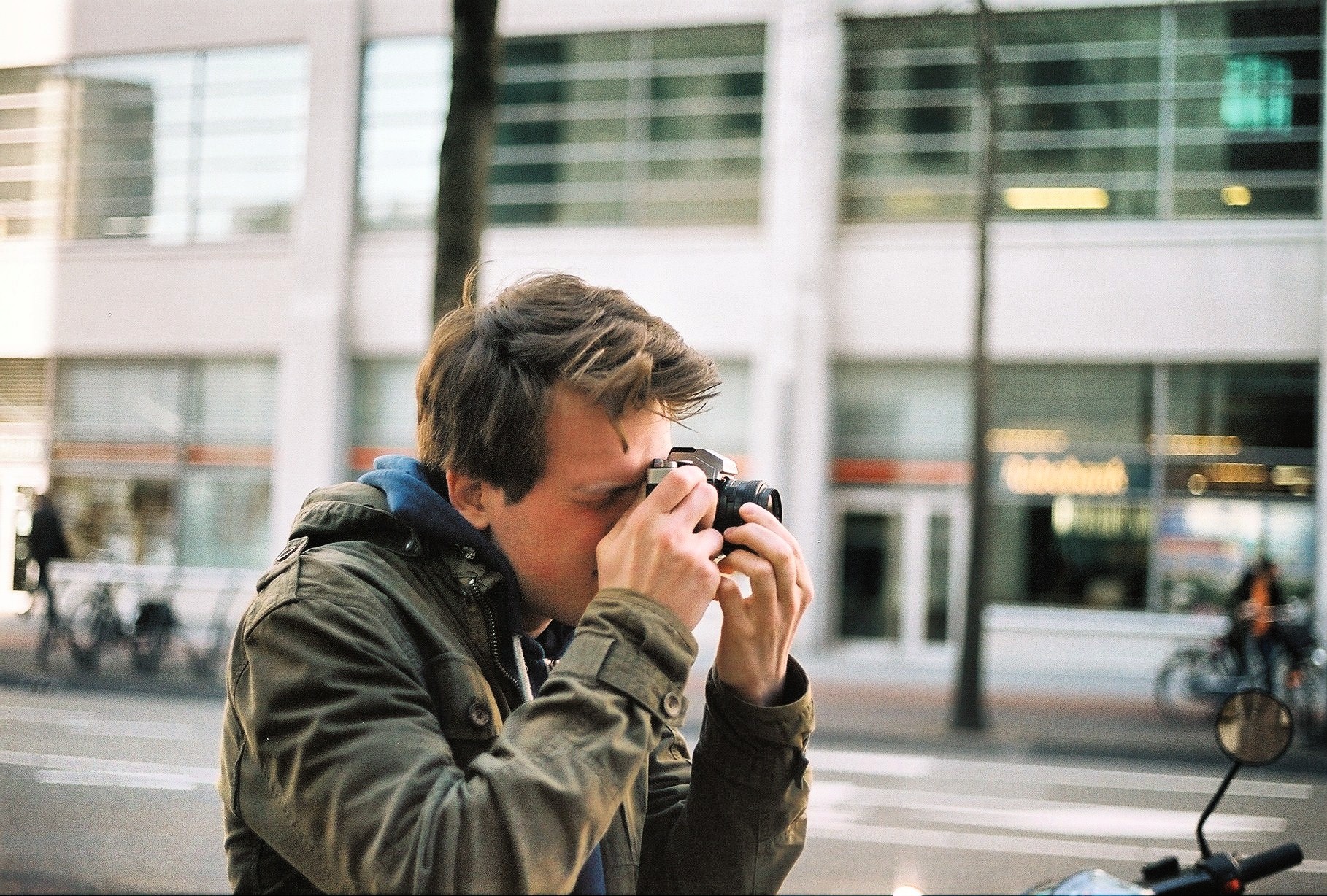 Arne Reijntjes is aan het fotograferen met een analoge fotocamera